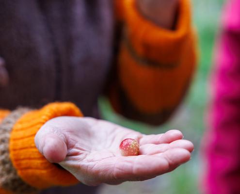 Kleines Objekt in der ausgestreckten Hand.