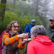Rita Landau erklärt Wanderern einen Pilz.