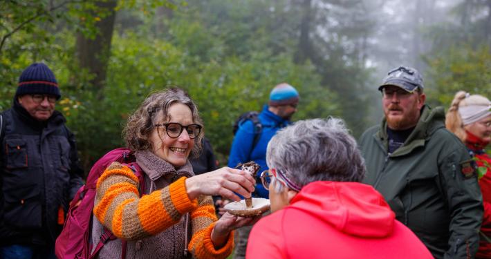 Rita Landau erklärt Wanderern einen Pilz.