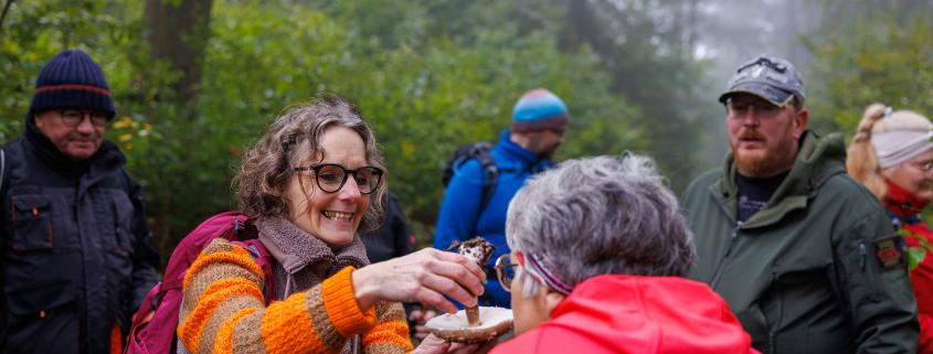 Rita Landau erklärt Wanderern einen Pilz.