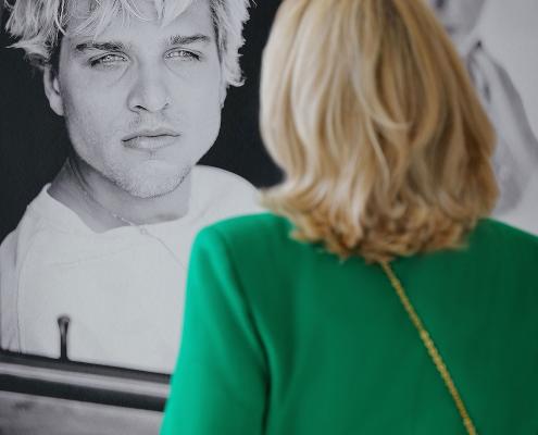 eine Besucherin schaut sich ein Foto in der Ausstellung an.