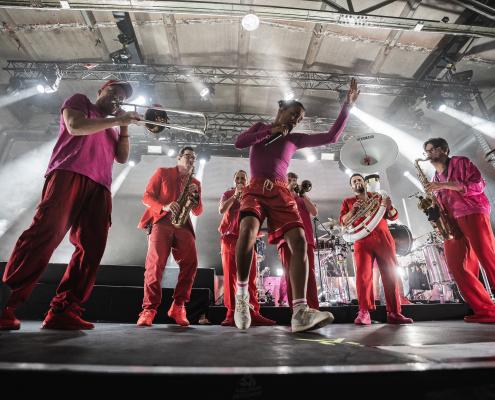 Die Münchner Urban-Brass-Band Moop Mama. Das Bild zeigt die Münchner Urban-Brass-Band Moop Mama, die für ihre energiegeladenen Auftritte mit Blasinstrumenten und Rap bekannt ist. Seit dem Ausstieg des langjährigen Frontmanns Keno im Jahr 2022 ist die neue Lead-Sängerin Älice fester Bestandteil der Gruppe