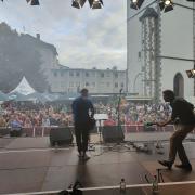 Das Bild zeigt eine Live-Performance auf einer Open-Air-Bühne dem Kirchenplatz in Gießen.