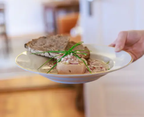 Kulinarisches im Café "Markt 17" Ein tiefer Teller mit einer Portion Sülze in Essig-Öl-Marinade mit Zwiebeln, frischem Schnittlauch und zwei Scheiben Graubrot.